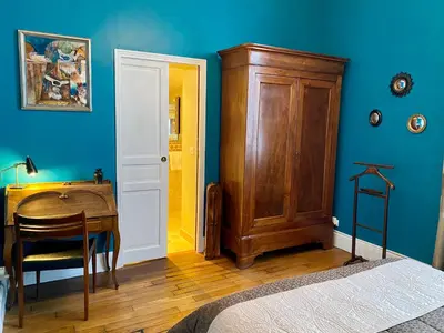 a bedroom with a wooden desk and a wooden door at Villa Suzanne - Lambesc centre in Lambesc