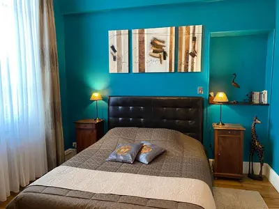 a bedroom with a bed with a blue wall at Villa Suzanne - Lambesc centre in Lambesc