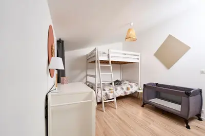 a small bedroom with a bunk bed and a desk at La Velleronnaise in Velleron