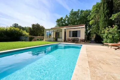 a swimming pool in front of a house at La Velleronnaise in Velleron