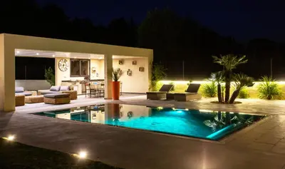 a swimming pool in a backyard at night at VILLA PALMA & SPA in LʼIsle-sur-la-Sorgue