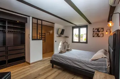 a bedroom with a bed and a walk in closet at VILLA PALMA & SPA in LʼIsle-sur-la-Sorgue