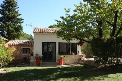 a small white house with a window and a yard at Logis au milieu des pins in Le Puy-Sainte-Réparade
