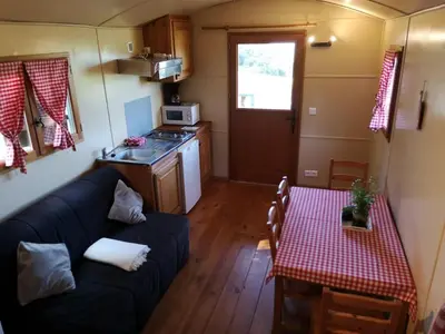 a small living room with a couch and a table at La Carriole dans le jardin in Ménerbes