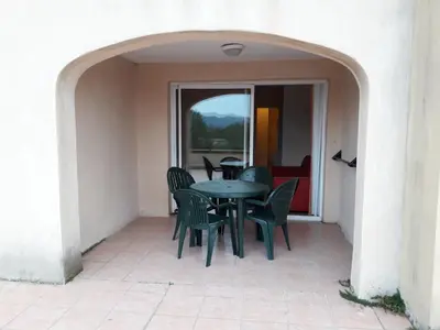 a patio with a table and chairs in a building at Studio sur le Domaine du Golf de Pont Royal in Mallemort