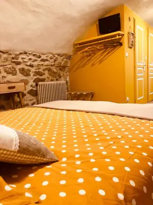 a bedroom with a large bed with a yellow at L'Atelier de Marie in Eyguières