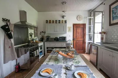 a kitchen with a table with plates of food on it at La Marisol in LʼIsle-sur-la-Sorgue
