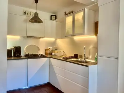 a white kitchen with white cabinets and a sink at Chez Suzanne in Bonnieux