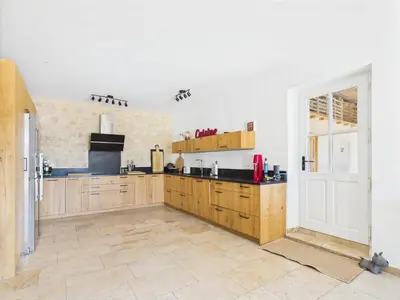 a large kitchen with wooden cabinets and a window at Magnifique Mas Provençal avec Piscine à Eygalières - 19 Couchages, 8 Chambres, Billard, et Plus ! - FR-1-599-3 in Eygalières