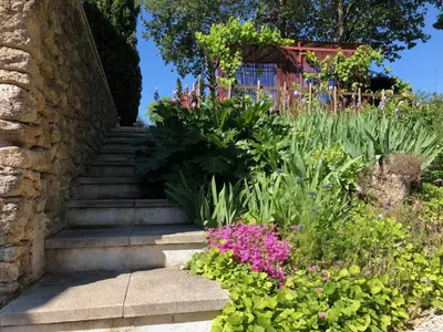 a garden with a fence and a building and trees at La bastide de Mauragne - Gîte les Iris in Apt