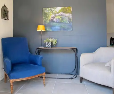 a living room with two chairs and a table and a couch at les Lauriers in Caromb