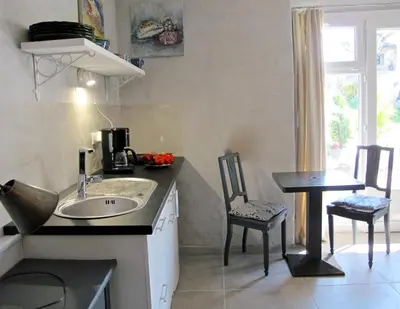a kitchen with a sink and a table and chairs at les Lauriers in Caromb
