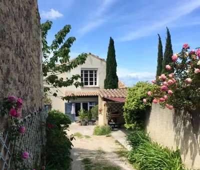 a white house with flowers on the fence at les Lauriers in Caromb
