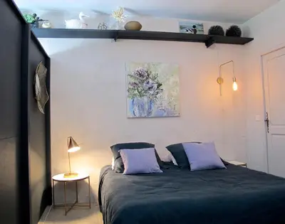 a bedroom with a bed and a painting on the wall at les Lauriers in Caromb
