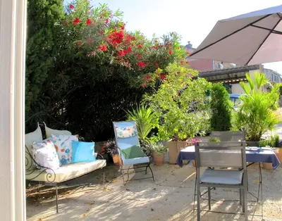 a patio with a table and two chairs and an umbrella at les Lauriers in Caromb