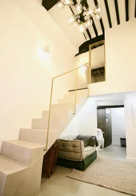 a living room with a staircase and a couch at Le Madeleine (duplex) in Aix-en-Provence