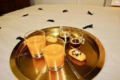 a tray with glasses of orange juice and a donut on a table at Le Madeleine (duplex) in Aix-en-Provence