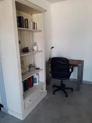 a desk and a chair in a room with a book shelf at Villa au pied du Ventoux in Mormoiron