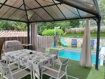 a patio with a table and chairs and a pool at Villa au pied du Ventoux in Mormoiron