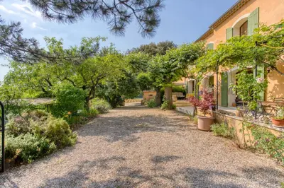 a driveway leading to a house with trees and plants at Mas de Bacalan in Mormoiron