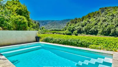 a swimming pool with a view of a vineyard at VILLA BEL - Entre paradis et vignes in Ménerbes