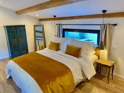 a bedroom with a large bed and a window at Le Vallon des Pins in La Cride