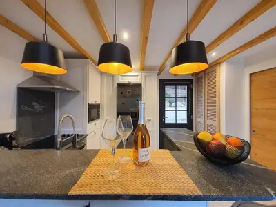 a kitchen with two wine glasses and a bowl of fruit at Le Vallon des Pins in La Cride