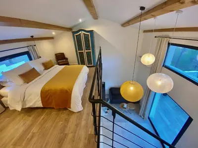 a bedroom with a bed and a large window at Le Vallon des Pins in La Cride