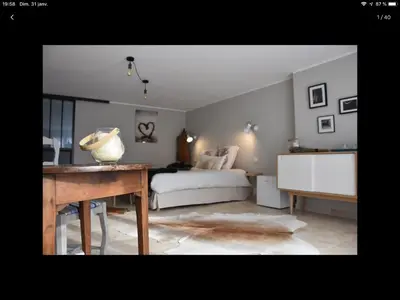 a bedroom with a bed and a table with a vase on it at La secrète chambre de la tour in Orgon