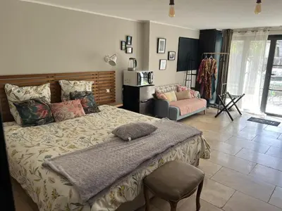 a bedroom with a large bed and a chair at La secrète chambre de la tour in Orgon
