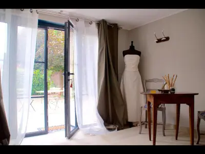 a dress hanging in a room next to a window at La secrète chambre de la tour in Orgon