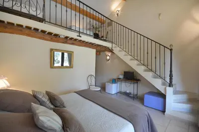 a bedroom with a large bed and a staircase at Chambres d'hôtes Le Vignoble in Cucuron