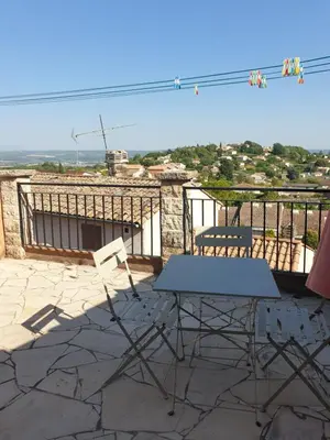 a table and chairs on a balcony with a view at Charmante maison de village au cœur du Luberon in Pierrevert