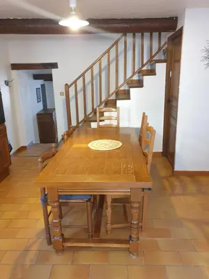 a dining room with a table and a staircase at Charmante maison de village au cœur du Luberon in Pierrevert