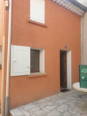 a orange building with a window and a door at Charmante maison de village au cœur du Luberon in Pierrevert