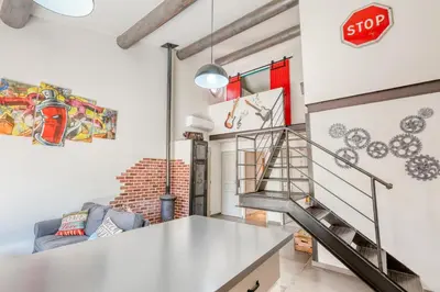 a staircase in a living room with a stop sign on the wall at Le JARDIN DES DELIS gite NEUF avec piscine bio UV in Saint-Saturnin-les-Apt