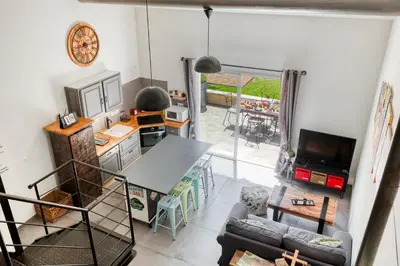 a living room with a table and a television at Le JARDIN DES DELIS gite NEUF avec piscine bio UV in Saint-Saturnin-les-Apt