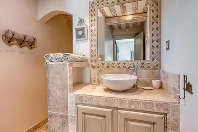 a bathroom with a sink and a mirror at Le JARDIN DES DELIS gite NEUF avec piscine bio UV in Saint-Saturnin-les-Apt