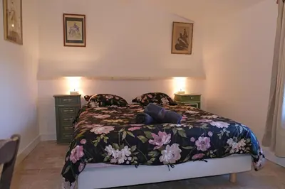 a bedroom with a bed with a floral bedspread at typical mas provençal with swimming pool in a small hamlet near mouriès in the alpilles in provence- 8 persons in Mouriès