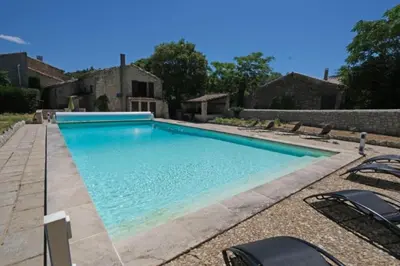 a swimming pool with chairs in front of a house at typical mas provençal with swimming pool in a small hamlet near mouriès in the alpilles in provence- 8 persons in Mouriès