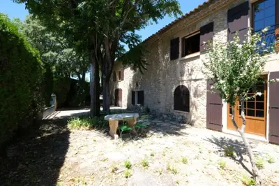 a stone building with a bench in the courtyard at typical mas provençal with swimming pool in a small hamlet near mouriès in the alpilles in provence- 8 persons in Mouriès