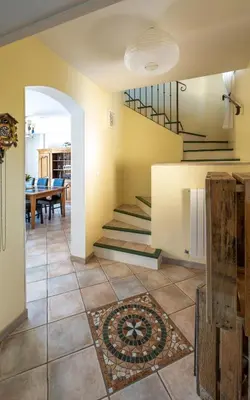 a living room with a staircase and a table at La Rose Des Vents in Modène