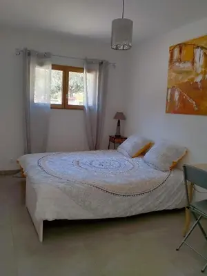 a bedroom with a large bed with a window at Gîte du domaine de l'Arbre de Vie in Saint-Chamas