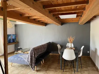 a living room with a bed and a table and chairs at Duplex lumineux sur gde TERRASSE, BALNEO double, parking privé, CLIM, local vélos in Entraigues-sur-la-Sorgue