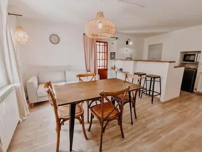a kitchen and dining room with a wooden table and chairs at La Source in Oppedette