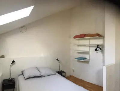 a bedroom with a bed and two lamps and a shelf at Studio 57 à Saignon in Saignon