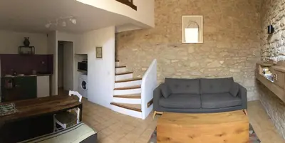 a living room with a couch and a stone wall at Studio 57 à Saignon in Saignon