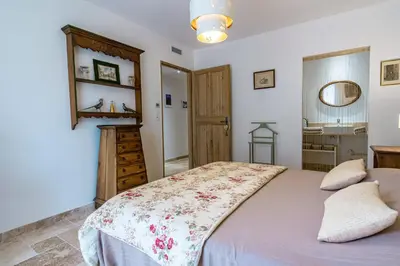 a bedroom with a large bed and a bathroom at Stunning house on the edge of the Luberon in Cheval-Blanc