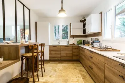 a kitchen with wooden cabinets and wooden stools at Stunning house on the edge of the Luberon in Cheval-Blanc