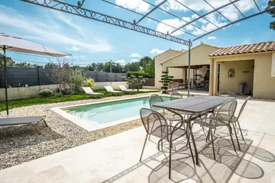 a patio with a table and chairs next to a swimming pool at Stunning house on the edge of the Luberon in Cheval-Blanc